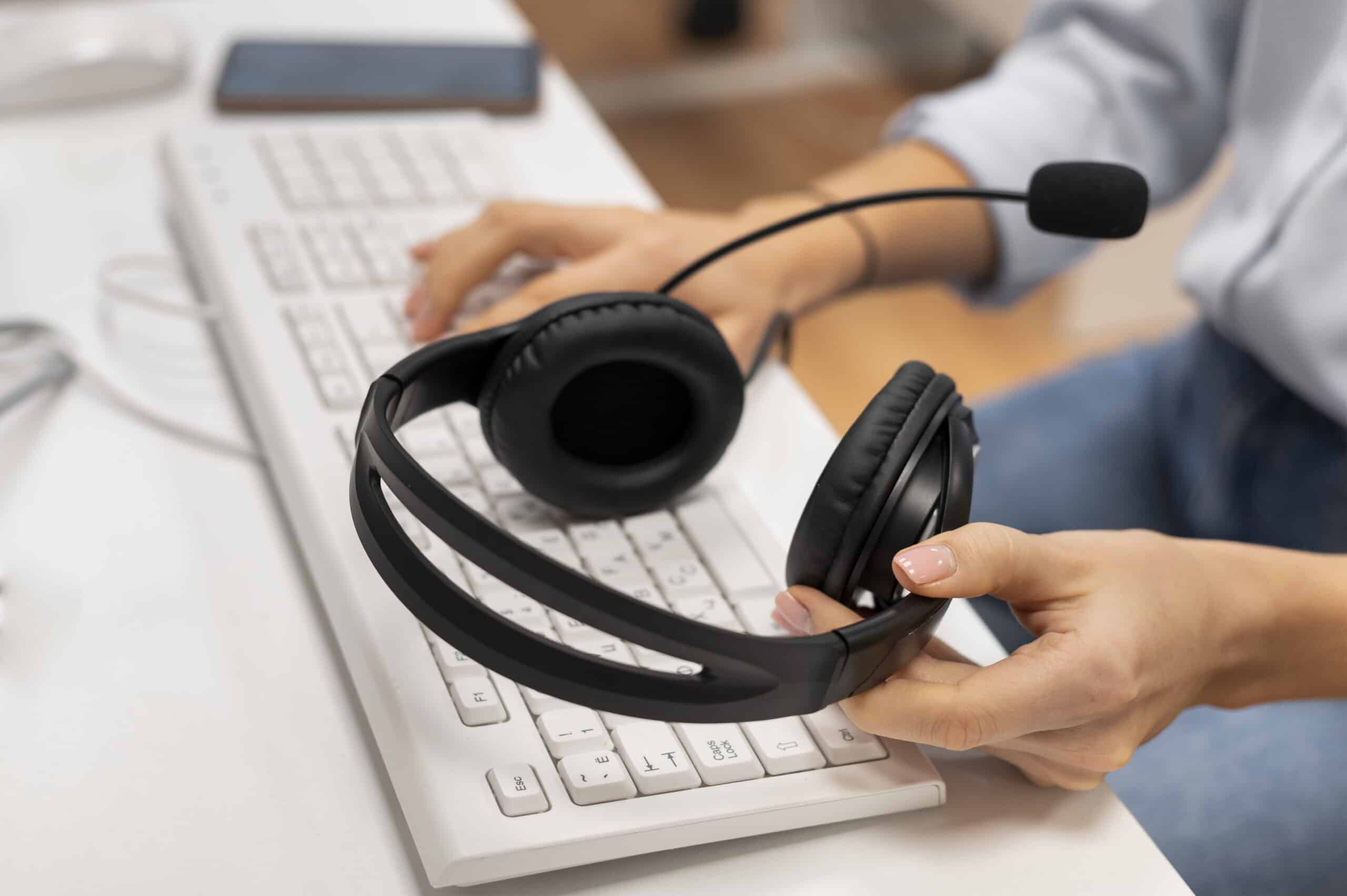 woman working call center holding pair headphones scaled